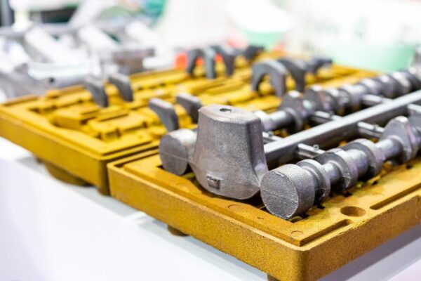 Resin-coated sand shell mold halves holding cast metal components