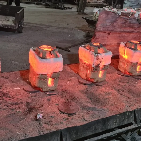 Freshly poured investment casting shell molds glowing red hot on a sand bed