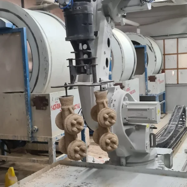 Robotic arm holding sand-coated wax clusters during investment casting shell building