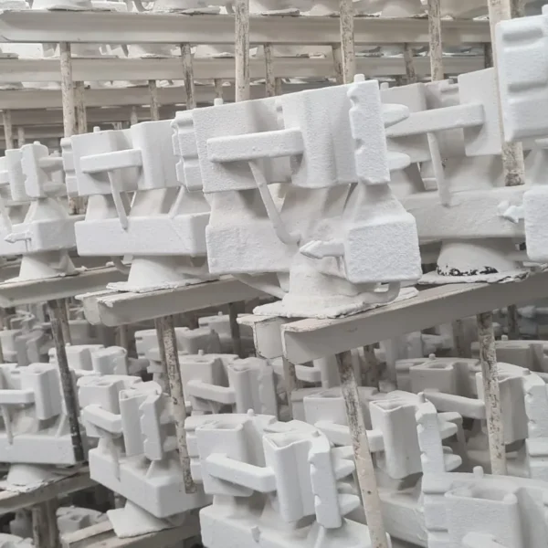 Rows of ceramic-coated wax pattern assemblies drying on racks before dewaxing
