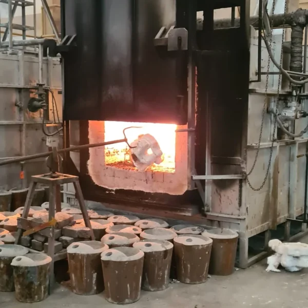 Ceramic shell mould being loaded into a glowing furnace at an investment casting foundry