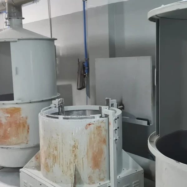 Workers tending ceramic slurry mixing tanks used to build investment casting shells